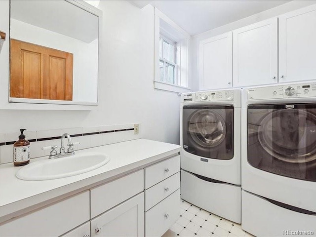 laundry room featuring independent washer and dryer, light flooring, and cabinet space