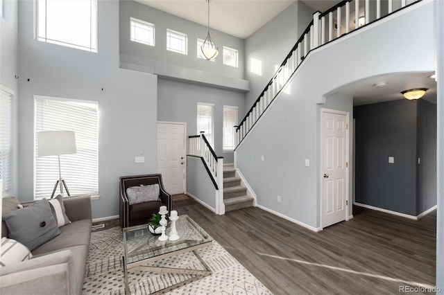 living room featuring dark hardwood / wood-style flooring and a towering ceiling