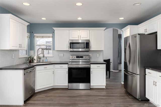 kitchen with backsplash, stainless steel appliances, sink, dark hardwood / wood-style floors, and white cabinetry