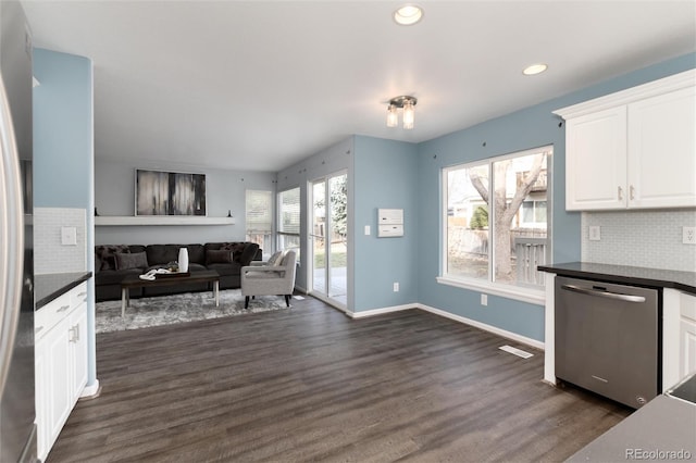 kitchen featuring stainless steel dishwasher, decorative backsplash, white cabinetry, and dark wood-type flooring