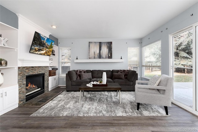 living room with a fireplace and dark wood-type flooring