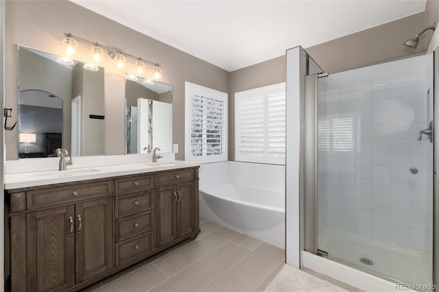 bathroom with tile patterned floors, vanity, and shower with separate bathtub