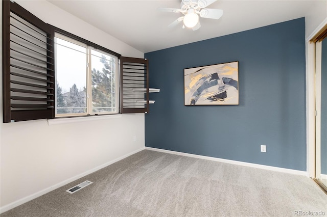 empty room with ceiling fan and carpet