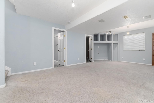 unfurnished room with a textured ceiling and light carpet