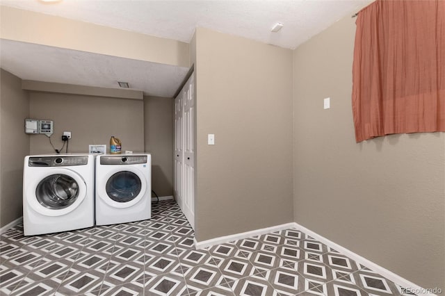 washroom featuring a textured ceiling and washing machine and dryer