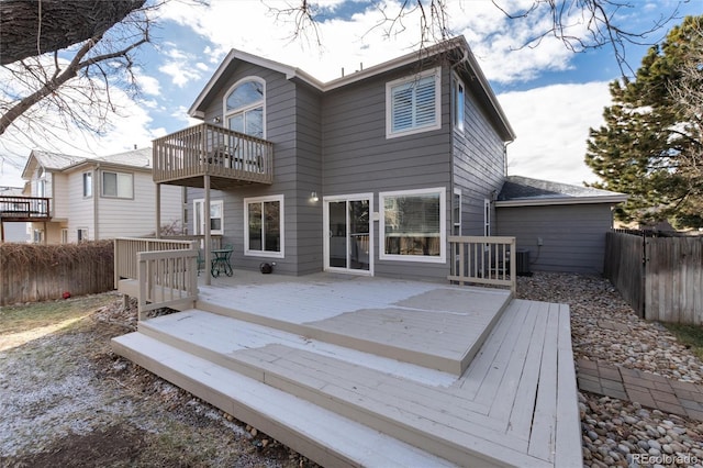 rear view of property with a wooden deck, a balcony, and central AC