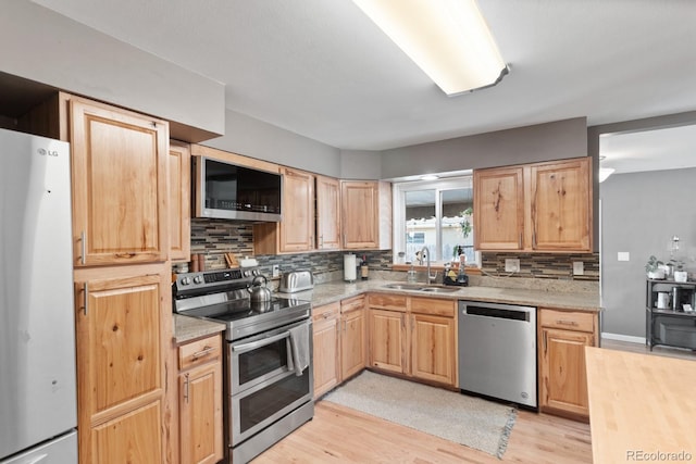 kitchen featuring butcher block counters, sink, light hardwood / wood-style floors, stainless steel appliances, and light brown cabinets