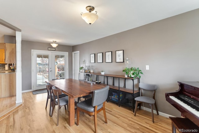 dining space with light wood-type flooring and french doors