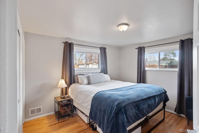 bedroom featuring multiple windows and light hardwood / wood-style flooring