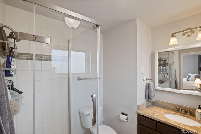 bathroom with vanity, toilet, and a shower with door