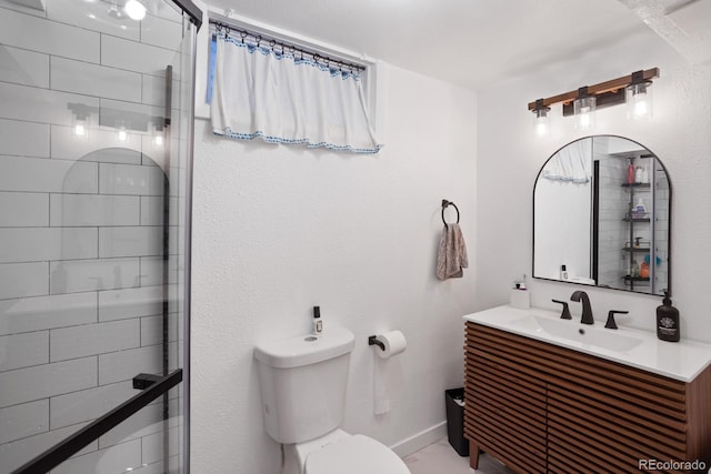 bathroom with vanity, toilet, and a tile shower