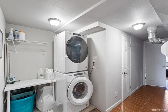 clothes washing area featuring stacked washing maching and dryer, dark wood-type flooring, and a textured ceiling