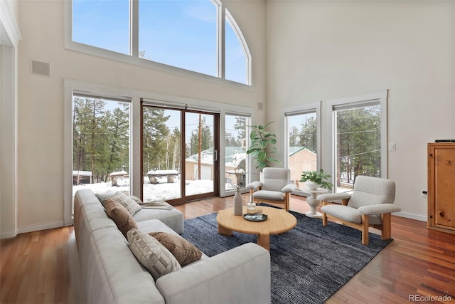 27987 Pine Grove Trl, Conifer, CO 80433 - living room with a towering ceiling, hardwood / wood-style floors, and baseboards