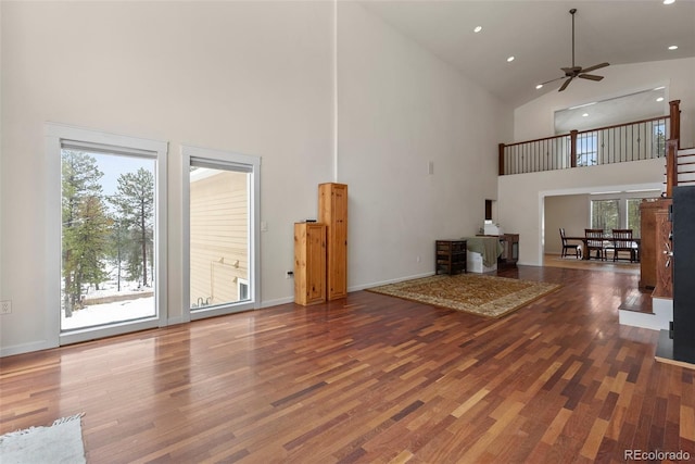 27987 Pine Grove Trl, Conifer, CO 80433 - unfurnished living room with high vaulted ceiling, wood finished floors, a ceiling fan, recessed lighting, and baseboards