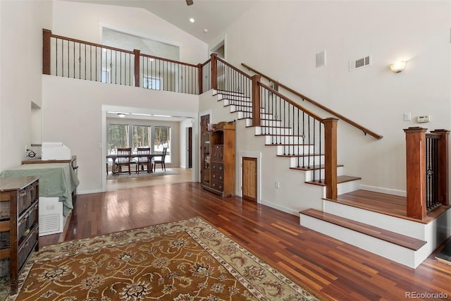 27987 Pine Grove Trl, Conifer, CO 80433 - stairs with wood finished floors, high vaulted ceiling, and baseboards