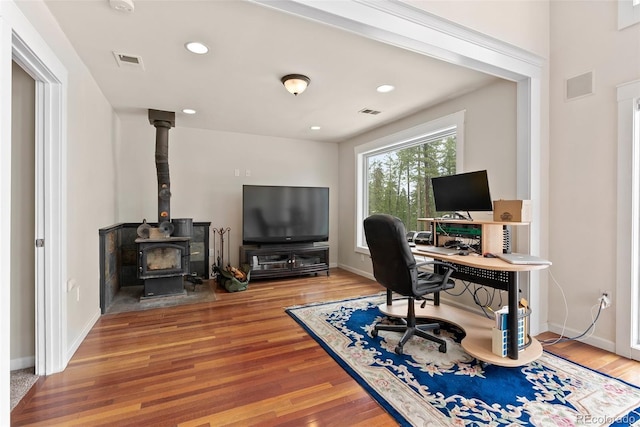 27987 Pine Grove Trl, Conifer, CO 80433 - home office featuring a wood stove, wood finished floors, baseboards, and recessed lighting