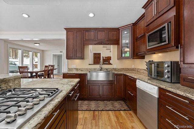 27987 Pine Grove Trl, Conifer, CO 80433 - kitchen with appliances with stainless steel finishes, a sink, light wood-type flooring, recessed lighting, and light stone counters