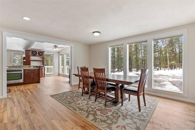 27987 Pine Grove Trl, Conifer, CO 80433 - dining space featuring light wood-type flooring, baseboards, a baseboard radiator, recessed lighting, and a textured ceiling