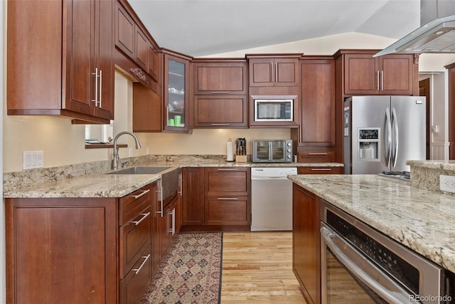 27987 Pine Grove Trl, Conifer, CO 80433 - kitchen featuring stainless steel appliances, vaulted ceiling, light wood-type flooring, light stone countertops, and glass insert cabinets