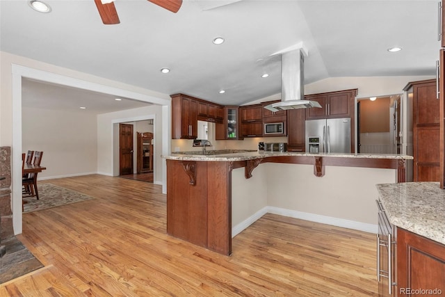 27987 Pine Grove Trl, Conifer, CO 80433 - kitchen featuring stainless steel appliances, a breakfast bar, ceiling fan, vaulted ceiling, and light wood finished floors