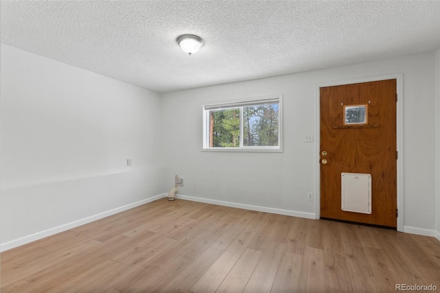 27987 Pine Grove Trl, Conifer, CO 80433 - spare room with light wood finished floors, baseboards, and a textured ceiling