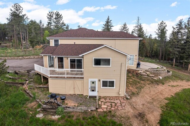 27987 Pine Grove Trl, Conifer, CO 80433 - back of house with a shingled roof and a wooden deck