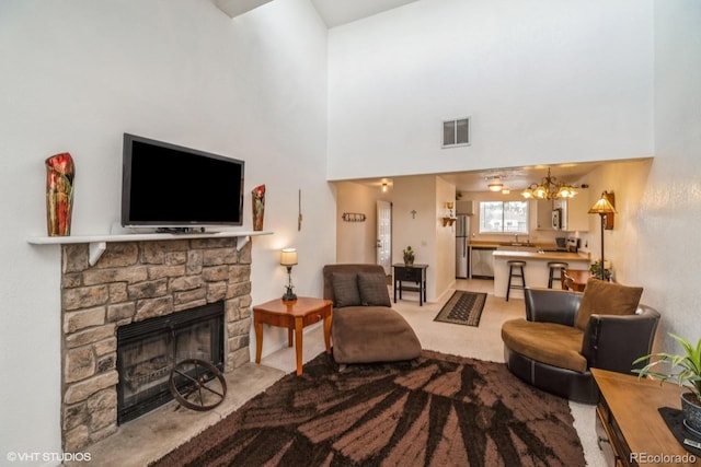 8654 Decatur St Unit 251, Westminster, CO 80031 - living area featuring a stone fireplace, carpet floors, a chandelier, and a high ceiling