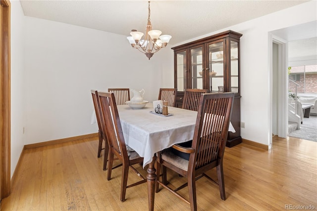 12522 W Virginia Ave, Lakewood, CO 80228 - dining room featuring a chandelier and light wood finished floors