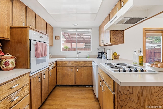 12522 W Virginia Ave, Lakewood, CO 80228 - kitchen with white appliances, exhaust hood, light wood-style floors, light countertops, and healthy amount of natural light
