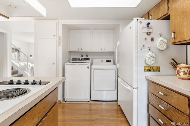 12522 W Virginia Ave, Lakewood, CO 80228 - kitchen with freestanding refrigerator, washer and dryer, light countertops, gas stovetop, and light wood-type flooring