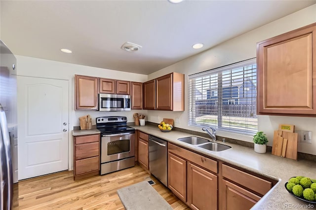 25792 E Cedar Pl, Aurora, CO 80018 - kitchen with appliances with stainless steel finishes, light wood-type flooring, recessed lighting, brown cabinets, and light countertops