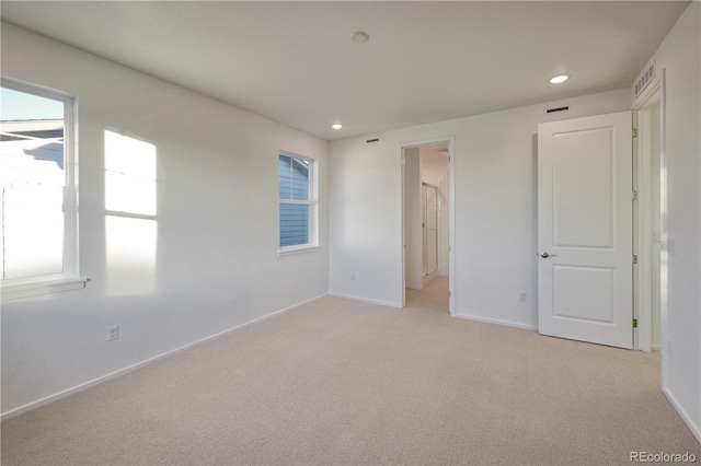 unfurnished bedroom with recessed lighting, light carpet, visible vents, and baseboards