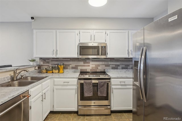 kitchen with stainless steel appliances, tasteful backsplash, sink, and white cabinets