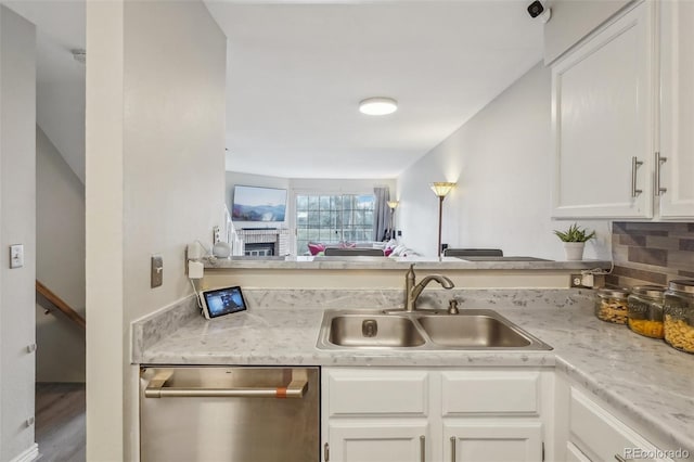 1818 S Quebec Way Unit 11-3, Denver, CO 80231 - kitchen featuring dishwasher, a sink, light countertops, white cabinetry, and a peninsula