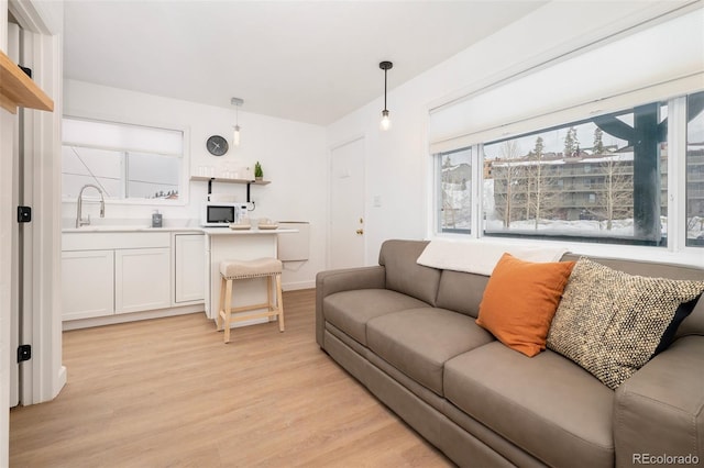 living room with sink and light wood-type flooring