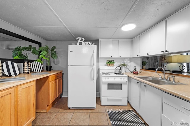 kitchen featuring light tile patterned floors, white appliances, sink, and white cabinets