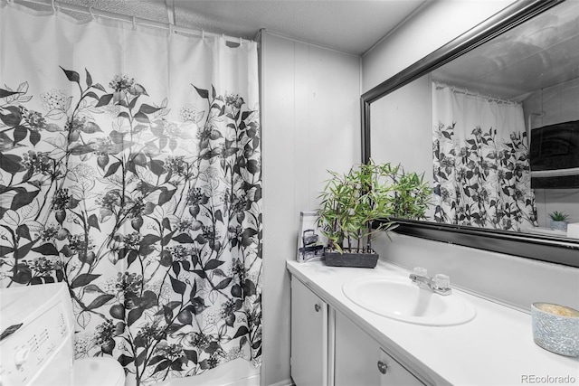 bathroom featuring vanity, toilet, and washer / clothes dryer