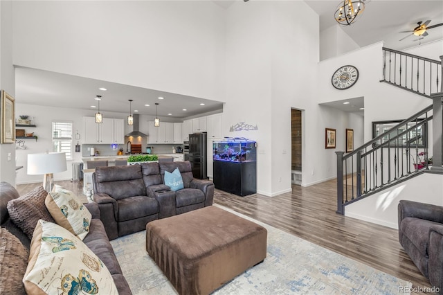 1114 Basalt Ridge Loop, Castle Rock, CO 80108 - living room with a high ceiling, stairs, light wood-type flooring, baseboards, and ceiling fan