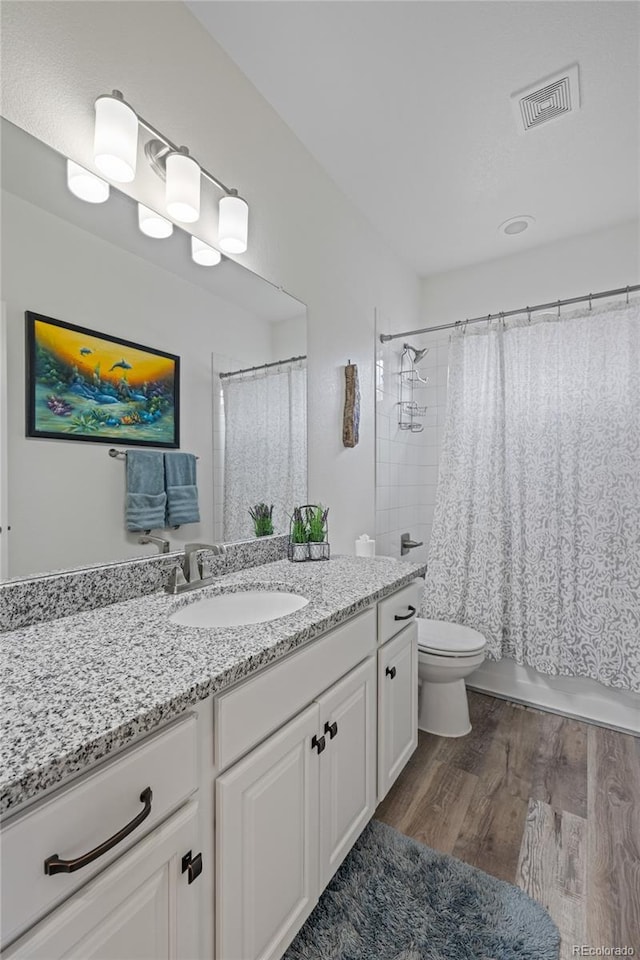 1114 Basalt Ridge Loop, Castle Rock, CO 80108 - bathroom featuring vanity, wood finished floors, toilet, and shower / bath combination with curtain
