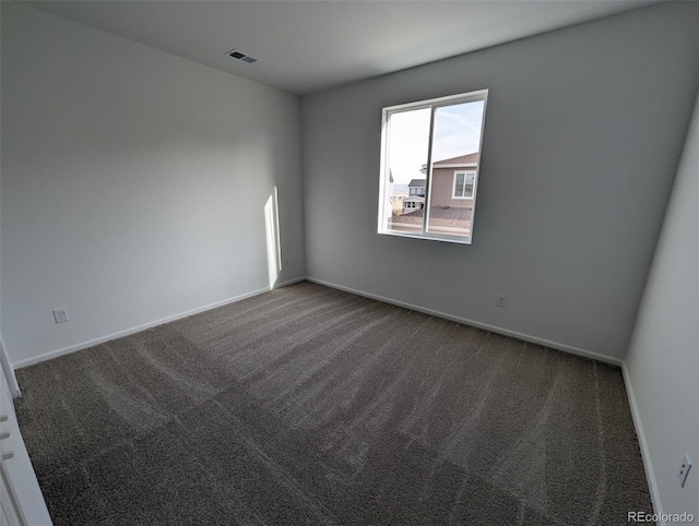 unfurnished room with dark colored carpet