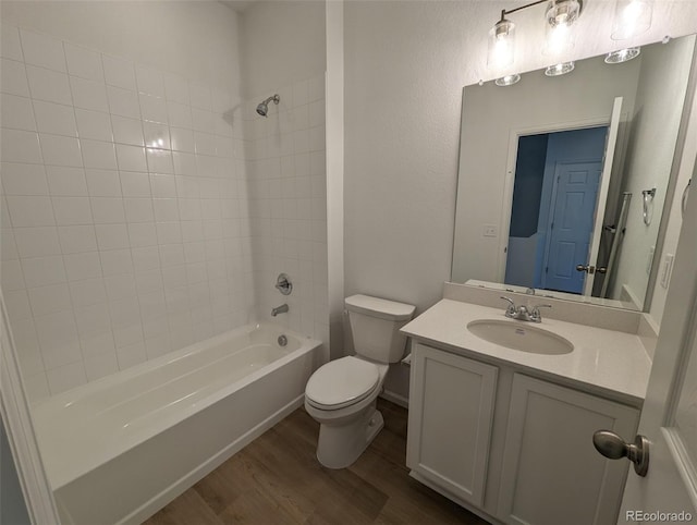 full bathroom with hardwood / wood-style floors, vanity, toilet, and shower / tub combination