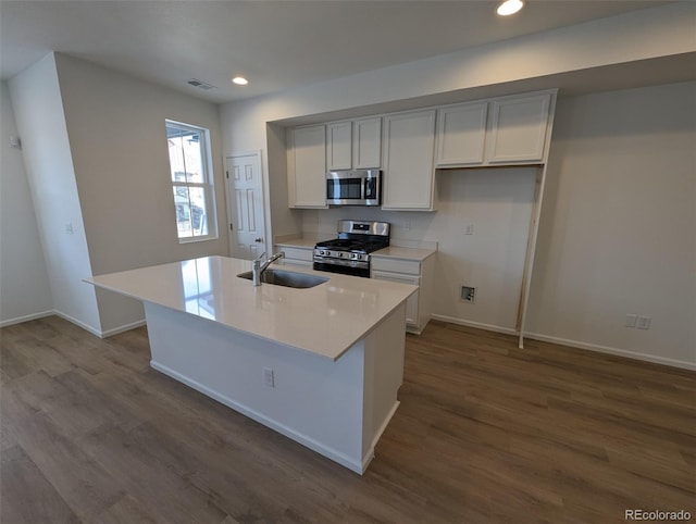 kitchen featuring white cabinetry, sink, hardwood / wood-style floors, a kitchen island with sink, and appliances with stainless steel finishes