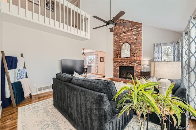 17509 E Kenyon Dr, Aurora, CO 80013 - living area with high vaulted ceiling, a ceiling fan, wood finished floors, and a brick fireplace