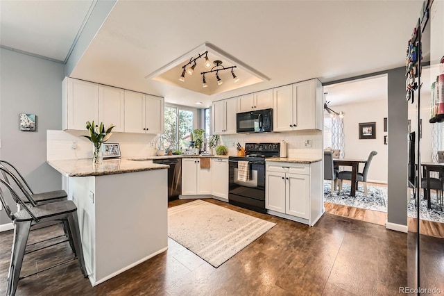 17509 E Kenyon Dr, Aurora, CO 80013 - kitchen with black appliances, a peninsula, white cabinets, and a raised ceiling