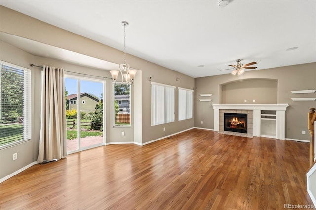 4960 Seton Pl, Colorado Springs, CO 80918 - unfurnished living room with ceiling fan, wood finished floors, a tile fireplace, and a chandelier