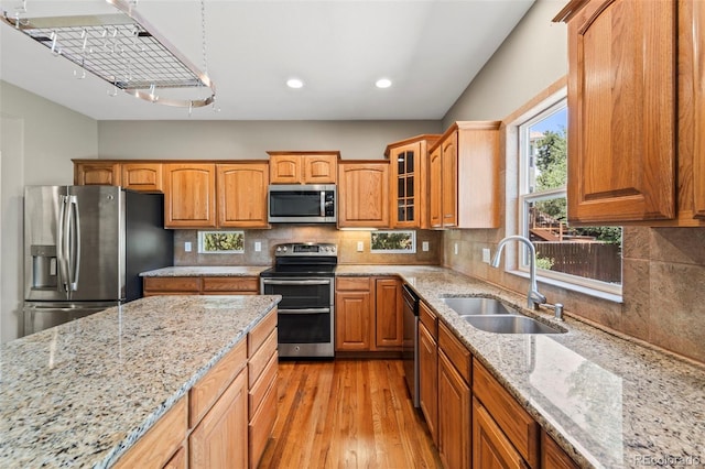 4960 Seton Pl, Colorado Springs, CO 80918 - kitchen featuring appliances with stainless steel finishes, light wood-style floors, light stone counters, glass insert cabinets, and recessed lighting