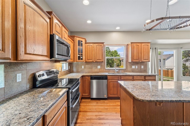 4960 Seton Pl, Colorado Springs, CO 80918 - kitchen with appliances with stainless steel finishes, light wood-style floors, light stone countertops, recessed lighting, and glass insert cabinets