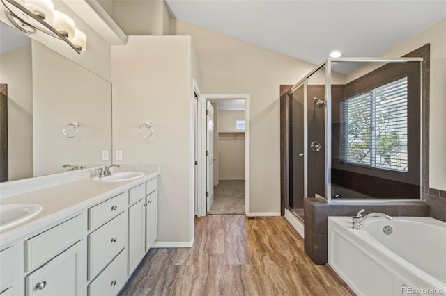 4960 Seton Pl, Colorado Springs, CO 80918 - bathroom featuring a stall shower, a bath, double vanity, wood finished floors, and a walk in closet