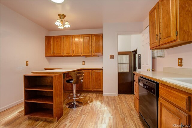 kitchen with light countertops, light wood-style flooring, black dishwasher, and brown cabinets