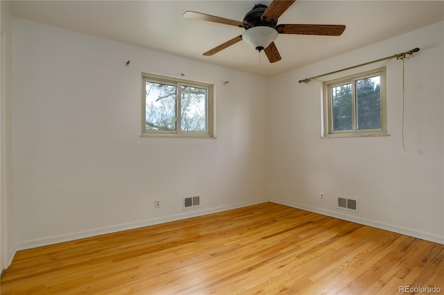 spare room featuring light wood-style flooring, baseboards, and visible vents